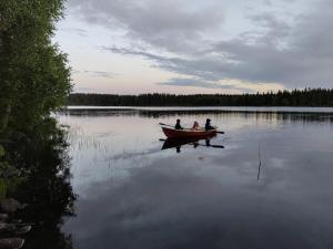 two people in a boat on a lake at Toivon pieni rantamökki in Sonka