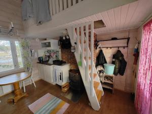 a small kitchen with a staircase in a tiny house at Toivon pieni rantamökki in Sonka +6 photos