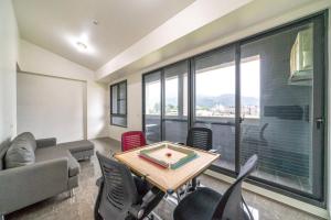 a living room with a table and chairs and a large window at 極小極大民宿 in Toucheng