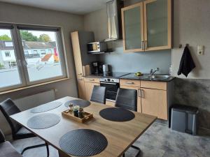 a kitchen with a wooden table and a kitchen with a dining room at Ferienhaus Thalia 2 in Übach-Palenberg