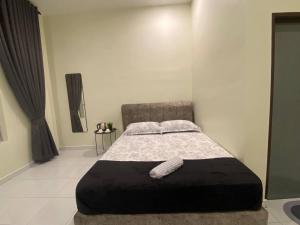 a bedroom with a large bed with a black ottoman at AZ Roomstay Pendang in Pendang