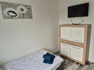 a bedroom with a bed and a dresser with a television at Ferienhaus Thalia 2 in Übach-Palenberg