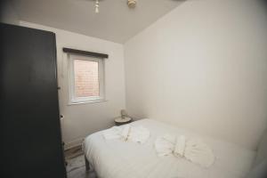 a bedroom with a white bed with bows on it at Modern Stranmillis 4 Bed in Belfast +1 photo