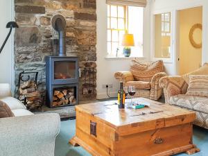 a living room with a wooden coffee table and a fireplace at Weavers Cottage in Kenmore