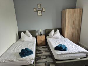 two beds in a room with blue pillows on them at Ferienhaus Thalia 2 in Übach-Palenberg
