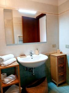 a bathroom with a white sink and a mirror at Incantevole appartamento, completo e confortevole con ampia terrazza privata e vista sulle colline Toscane, a pochi chilometri dal mare, vicino ai percorsi per bici della zona in Massa Marittima +44 photos