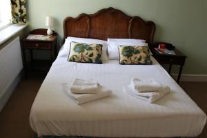 WhittleseyにあるFalcon Hotelのベッドとタオル2枚のある寝室
