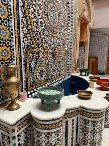 a room with a wall covered in colorful tiles at Riad Majorelle in Rabat
