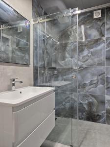 a bathroom with a sink and a glass shower at apartments Lviv Vernygory 14 in Lviv