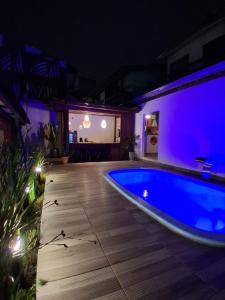 a swimming pool at night with purple lights at Pousada Makani Kai in Florianópolis +19 photos