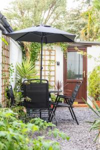 a table and two chairs under an umbrella at Jungle Lodge in Rustington