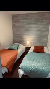two beds sitting next to each other in a room at Chalet Guerlédan in Caurel
