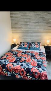 a bedroom with a bed with a floral comforter at Chalet Guerlédan in Caurel