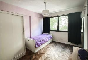 a bedroom with a purple bed and a window at DEPARTAMENTO pleno centro MAR DEL PLATA in Mar del Plata