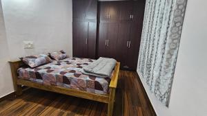 a bedroom with a bed and wooden floors and cabinets at Shree Gowthameshwara Nilaya in Chikmagalūr