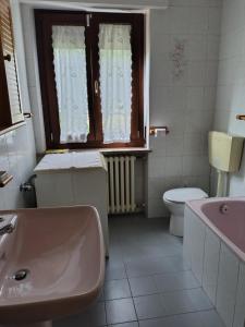 a bathroom with a sink and a toilet and a window at agrifoglio in Borgofranco dʼIvrea