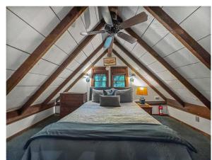 a attic bedroom with a bed and a ceiling fan at JME Retreat in Colwell