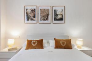 a bedroom with a white bed with four pictures on the wall at Dream Room Apartment in Illasi