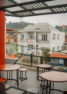 a balcony with tables and a view of a building at Asoka Syariah Nexura Collection in Dieng