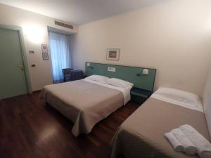 a hotel room with two beds and a window at Deco Hotel in Perugia +49 photos