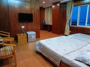 Un dormitorio con una cama y un televisor de pantalla plana. en Jolilian Hotel Bãi Sau, en Vung Tau 50 fotos más