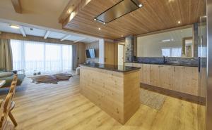 a kitchen with a island in a room with wooden walls at Chalet Almglück by we rent, JOKERCARD INCLUDED in Saalbach-Hinterglemm +23 photos