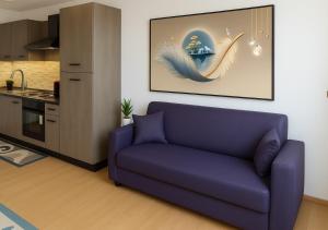 a living room with a purple couch and a kitchen at Chic house in Avezzano
