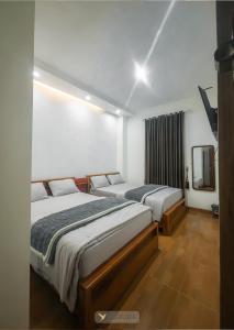 a bedroom with two beds and a mirror at Asoka Syariah Nexura Collection in Dieng +32 photos