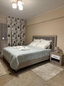 a bedroom with a bed with two towels on it at Geany Apartament Ultracentral in Craiova