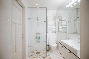 a white bathroom with a toilet and a sink at Guldgränd in Stockholm +89 photos
