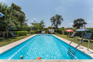 a swimming pool in a yard with an umbrella at Sevenfarm Turismo Rural in Mangualde