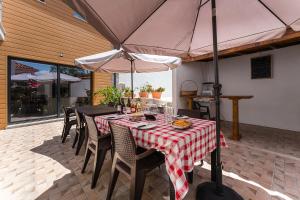 a table and chairs with an umbrella on a patio at Sevenfarm Turismo Rural in Mangualde