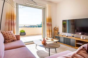 a living room with a couch and a tv at Le Penthouse de 220m2 - Jacuzzi - 3 Parkings - Climatisation - Terrasse in Menton