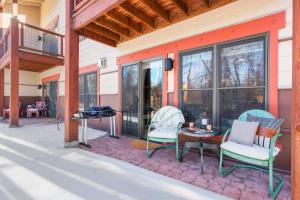 a patio with chairs and a table and windows at Basecamp Stays: Upscale Getaway Shuttle Hot Tubs in Driggs