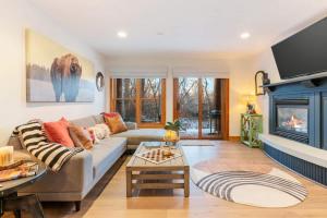a living room with a couch and a fireplace at Basecamp Stays: Upscale Getaway Shuttle Hot Tubs in Alta