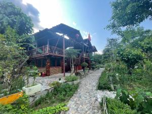 a house with a stone path in front of it at Sông Quê Homestay in Quảng Uyên