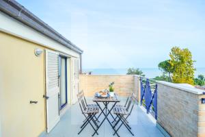 eine Terrasse mit zwei Stühlen und einem Tisch auf einem Balkon in der Unterkunft Homiday - Green Bay Village in Pineto