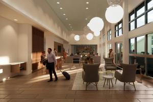 un homme debout dans un hall avec une valise dans l'établissement Element Branson, à Branson