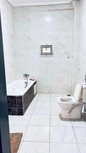 a bathroom with a tub and a toilet and a sink at Tulivu Rëcc in Nditarh