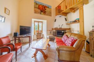 una sala de estar con un sofá y una chimenea en Chez Félicie - 2 grands gîtes, en Albepierre