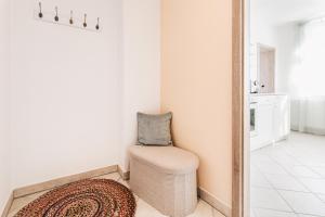 una stanza con una sedia, un tappeto e uno specchio di Creekside Colors - Playful Apartment a Löbau