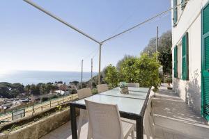 a table and chairs on a balcony with a view of the ocean at Gli Ulivi in Bogliasco