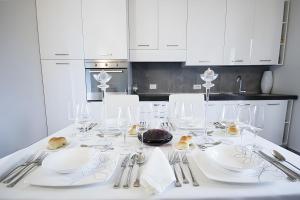 a white kitchen with a table with glasses and silverware at Villa Eden in Castiglione di Sicilia