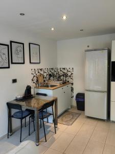 a kitchen with a table and a refrigerator at Studio Koper in Koper