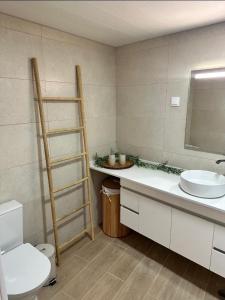 a bathroom with a sink and a toilet and a mirror at Mocha House in Machico