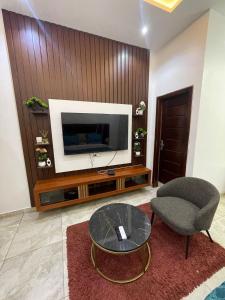 アクラにあるRosewood residence 2 bedroom duplex with views and bathtubのテレビと椅子とテーブルのあるリビングルーム +4枚の写真