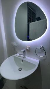 アクラにあるRosewood residence 2 bedroom duplex with views and bathtubのバスルーム(白い洗面台、円形鏡付)