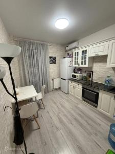 a kitchen with a table and a white refrigerator at Chalupa Na kopci in Hlinná