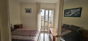a bedroom with two beds and a door to a balcony at Centrico piso en Marbella in Marbella