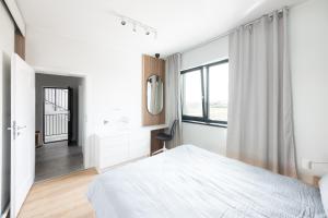 Un dormitorio blanco con una cama y una ventana. en Aris Apartments - free parking - powered by NEO, en Dumbrăviţa